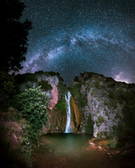 Wall Mural - Night landscape, A waterfall flows down the mountain to a small lake, while the milky way illuminates the image. A beautiful waterfall in Spain, the stars illuminate the lake.