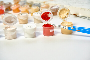 A set of paints, brushes and canvas for painting by numbers. Hobbies and leisure. Drawing at home.