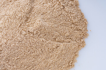 fresh natural buckwheat flour on a white acrylic background