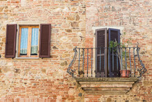 Italy, Tuscany, Montepulciano, Stony And Brick Facade Of House With Carved Metal Balcony And Latticed Sun Blinds