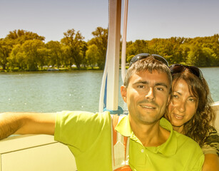 Wall Mural - Happy young couple  on a boat cruise