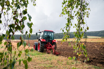 Farmer in tractor preparing land for sowing, plowing the field