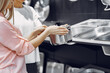 © prostooleh - Woman examines various items of dishes. Beautiful woman shopping tableware in supermarket. Manager helps a costumer.