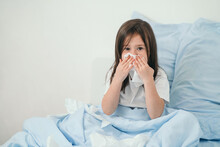 The Little Girl Caught A Cold. Children Sneeze Into A Handkerchief. The Child Is Ill And Is Being Treated At Home. Seasonal Colds In Children