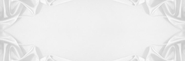 White abstract festive elegant background. Beautiful drapery of soft folds of fabric. Border. Luxurious silk satin background with copy space for your design. Wide banner. Wedding, anniversary concept