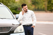 © Pixel-Shot - Handsome man talking by mobile phone near modern car