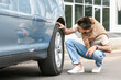 © Pixel-Shot - Handsome man checking tires of modern car