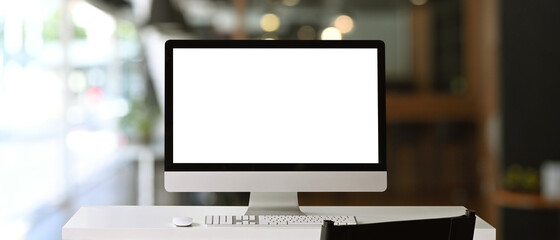 front view of a computer with blank on white table at contemporary office.