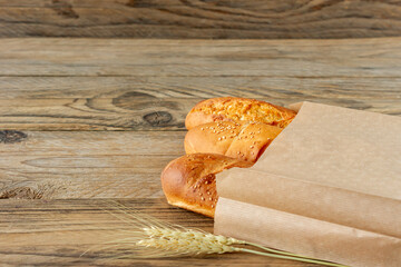 Wall Mural - arranged french baguettes in paper bag and wheat on rustic wooden tabletop