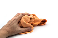 Closeup Of Orange Cleaning Towel In Hand On White Background
