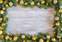 Green Branch Of Christmas Tree Decorated With Christmas Decor On Wooden Table