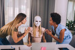 © Mediteraneo - Young businesswomen working together in office. One woman is wearing a mask.