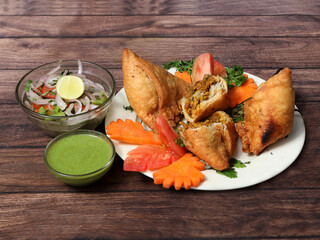 Wall Mural - Chicken Samosa, Famous traditional Arabic, Middle East, Asian cuisine. Triangular arabic chicken samosa served over a rustic wooden background, selective focus