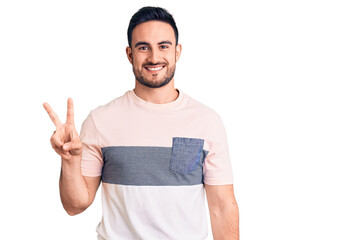 Young handsome man wearing casual clothes showing and pointing up with fingers number two while smiling confident and happy.