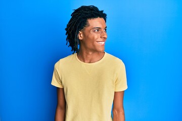 Wall Mural - Young african american man wearing casual clothes looking to side, relax profile pose with natural face and confident smile.