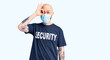 © Krakenimages.com - Young handsome man wearing security t shirt and medical mask smiling happy doing ok sign with hand on eye looking through fingers