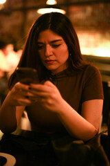 Young woman at the festival drinking beer and using mobile phone