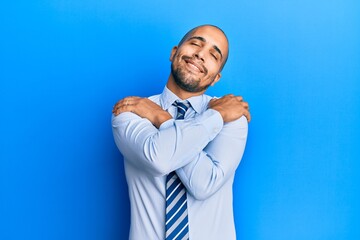 Sticker - Hispanic adult man wearing business shirt and tie hugging oneself happy and positive, smiling confident. self love and self care