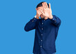 © Krakenimages.com - Young handsome man wearing casual shirt covering eyes with hands and doing stop gesture with sad and fear expression. embarrassed and negative concept.