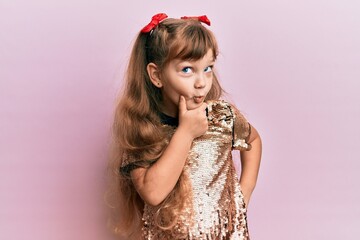 Wall Mural - Little caucasian girl kid wearing festive sequins dress with hand on chin thinking about question, pensive expression. smiling with thoughtful face. doubt concept.