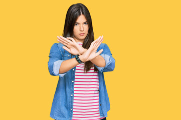 Sticker - Young brunette woman wearing casual clothes rejection expression crossing arms and palms doing negative sign, angry face