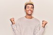 © Krakenimages.com - Young african amercian man wearing prince crown very happy and excited doing winner gesture with arms raised, smiling and screaming for success. celebration concept.