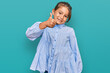 © Krakenimages.com - Little beautiful girl wearing casual clothes smiling happy and positive, thumb up doing excellent and approval sign