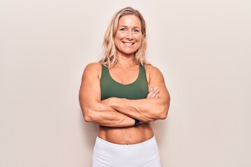 Middle age caucasian blonde woman wearing sportswear happy face smiling with crossed arms looking at the camera. positive person.