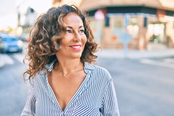 Middle age hispanic woman smiling happy walking at the city.