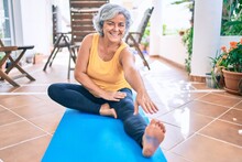 Middle Age Woman With Grey Hair Smiling Happy Doing Exercise And Stretching On The Terrace At Home