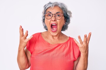 Sticker - Senior hispanic grey- haired woman wearing casual clothes and glasses crazy and mad shouting and yelling with aggressive expression and arms raised. frustration concept.