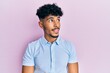 Young arab handsome man wearing casual clothes looking to side, relax profile pose with natural face and confident smile.