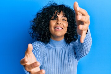 Young hispanic woman wearing casual clothes looking at the camera smiling with open arms for hug. cheerful expression embracing happiness.