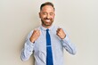 © Krakenimages.com - Handsome middle age man wearing business shirt and tie excited for success with arms raised and eyes closed celebrating victory smiling. winner concept.