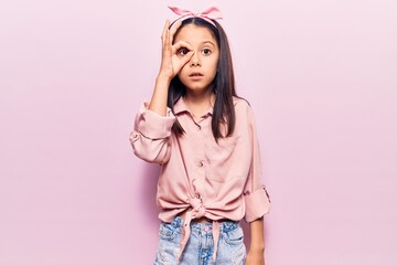 Poster - Beautiful child girl wearing casual clothes doing ok gesture shocked with surprised face, eye looking through fingers. unbelieving expression.