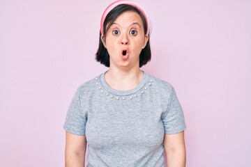 Wall Mural - Brunette woman with down syndrome wearing casual clothes scared and amazed with open mouth for surprise, disbelief face