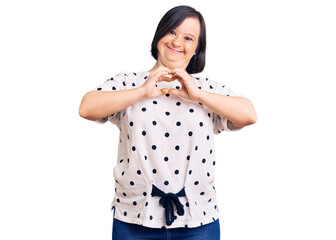 Canvas Print - Brunette woman with down syndrome wearing casual clothes smiling in love doing heart symbol shape with hands. romantic concept.