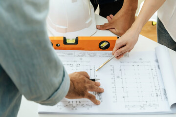 Wall Mural - engineer, architect, construction worker team working and pointing on drawing blueprint on workplace desk in meeting room office at construction site, contractor, teamwork, construction concept