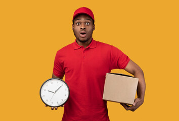 Wall Mural - Surprised black delivery man holding box and clock