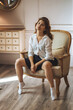 © Smeilov - The girl is sitting on a chair in a short skirt with her legs spread