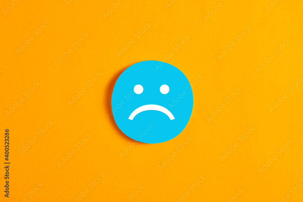 Blue round circle with a sad face icon against yellow background. - obrazy, fototapety, plakaty 