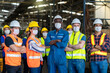 © Thirawatana - Workers and workers are standing in the factory. Group Staff Standing In Engineering Factory.