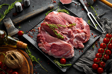 Piece of fresh raw pork from the neck, with ingredients and spices on a kitchen background. Meat. Top view. Rustic style.