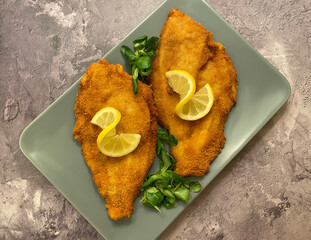 Classic breaded plaice fish fillets, coated in flour, egg, breadcrumbs and fried in oil to golden. Served with lemon.