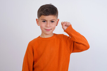 Wall Mural - Cute Caucasian kid boy wearing knitted sweater against white wall pointing up with fingers number ten in Chinese sign language Shi