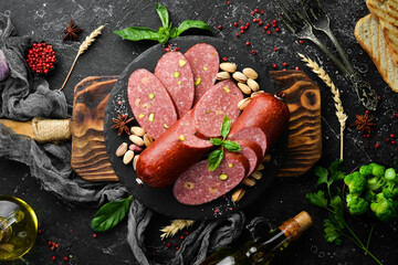 Wall Mural - Salami with nuts: pistachios and hazelnuts. Top view. Rustic style.