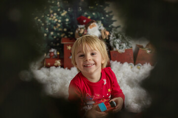 Cute blond toddler child, playing with snow and christmas decoration