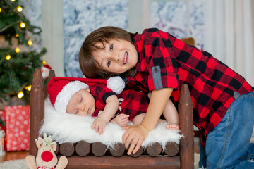 Sticker - Portrait of newborn baby and his brother in Santa clothes, sleeping in little baby bed