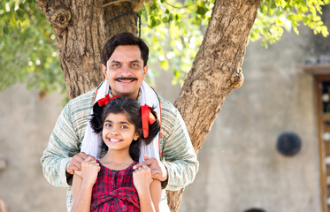 Wall Mural - Rural Indian father with daughter looking at camera