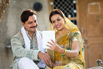 Wall Mural - Rural Indian wife and husband using digital tablet at village